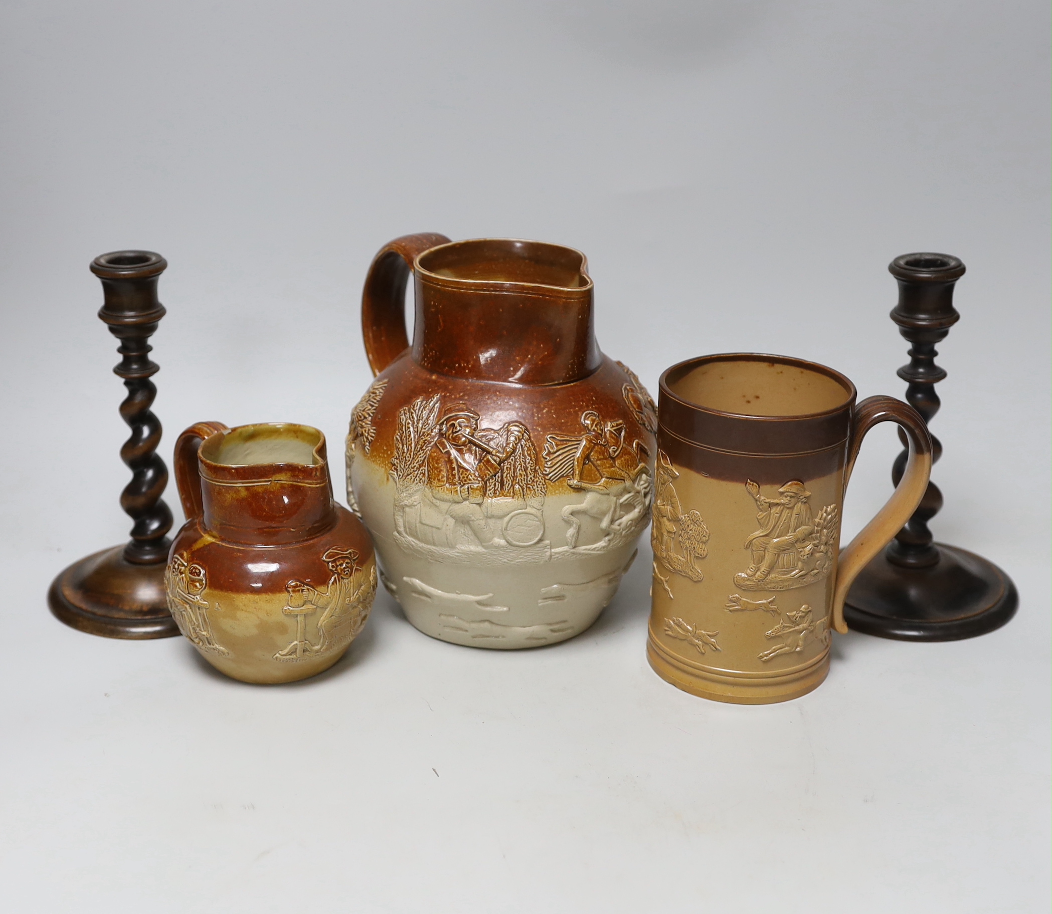 A group of three salt-glazed stoneware vessels and a pair of walnut barley-twist candlesticks, the largest 19cm high